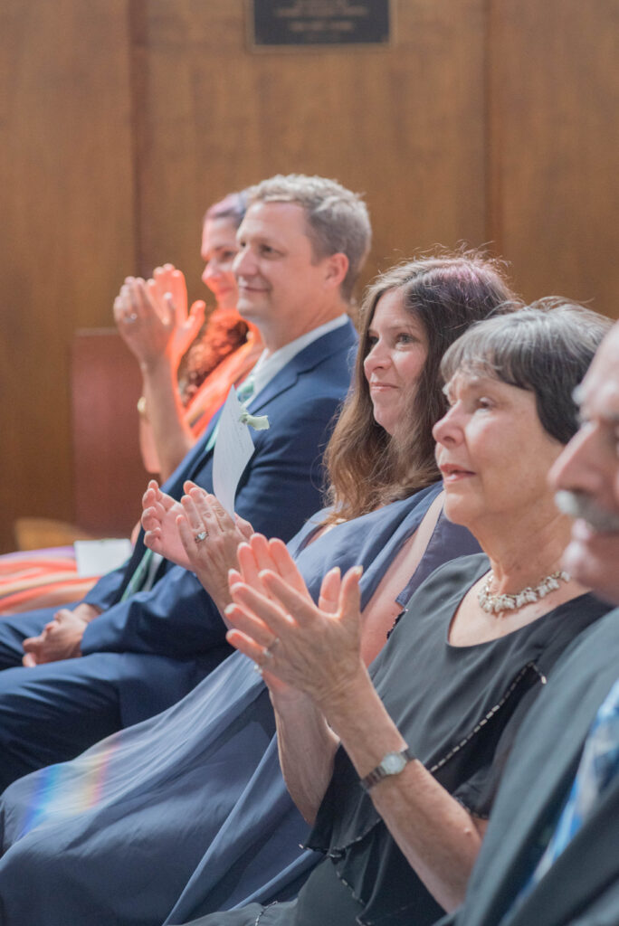 guests clapping during wedding ceremony
